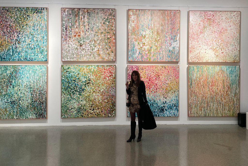 Debra Hutton with her expressionist paintings in the studio